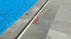 Kolam denang dengan decking batu alam. Ini cara membersihkan noda hitam di batu decking kolam renang.