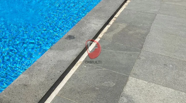 Kolam denang dengan decking batu alam. Ini cara membersihkan noda hitam di batu decking kolam renang.