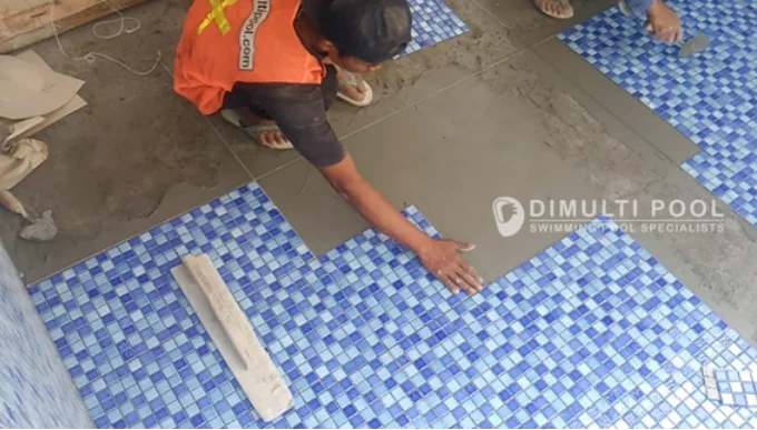 Pemasangan keramik motif mozaik, bisa jadi pilihan untuk kolam Olympic.